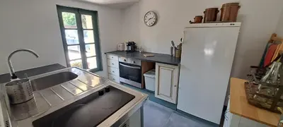 a kitchen with a sink and a refrigerator at Location Le Tilleul in Pélissanne