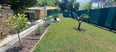 a garden with two trees in the grass at Location Le Tilleul in Pélissanne