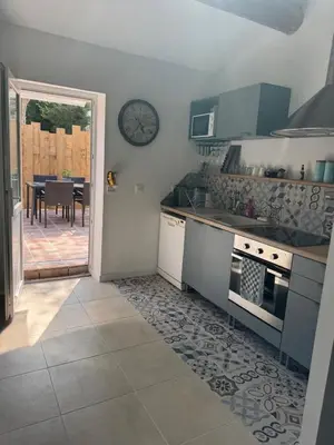 a kitchen with a table and a clock on the wall at Maset Lou Pitchoun in Saint-Rémy-de-Provence