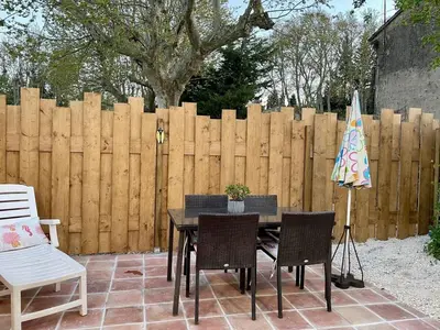 a patio with a table and chairs and a fence at Maset Lou Pitchoun in Saint-Rémy-de-Provence