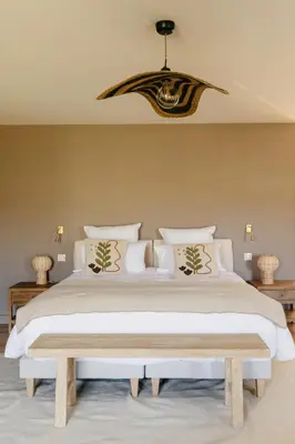 a bedroom with a large white bed and a chandelier at Mas de l'Etoile in Aureille