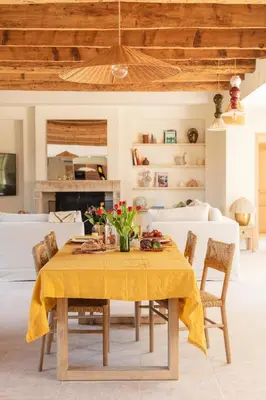 a dining room table with a yellow table cloth at Mas de l'Etoile in Aureille