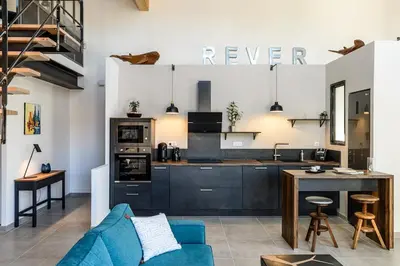 a kitchen with a blue couch in a living room at Loft en Provence - Terrasse-Climatisation-Proche Golf et Luberon in Vernègues