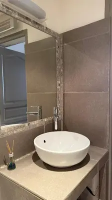 a bathroom with a white sink and a mirror at Studio dans le centre ancien in Carpentras