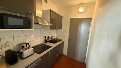 a kitchen with a sink and a microwave at Studio dans le centre ancien in Carpentras