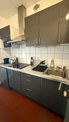 a kitchen with gray cabinets and a sink at Studio dans le centre ancien in Carpentras