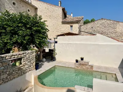 a swimming pool in a yard next to a building at L'Ecrin de Mérindol in Mérindol