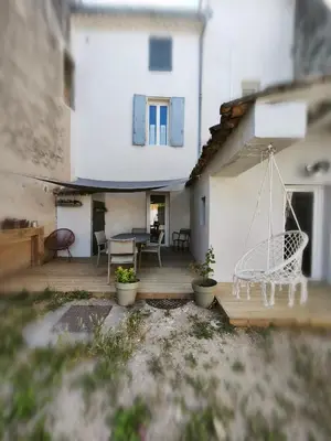 a patio with a swing and a house at La dominique in Villes-sur-Auzon