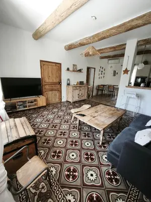 a living room with a table and a tv at La dominique in Villes-sur-Auzon