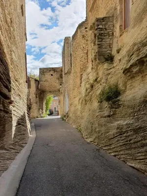 an alley in an old stone building with an archway at La tanière d'Agoult in Goult