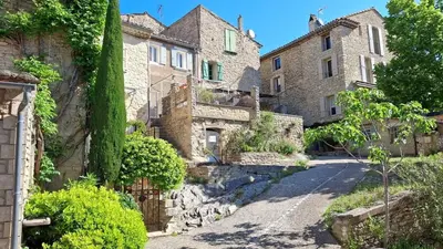 an old stone house with a driveway at La tanière d'Agoult in Goult