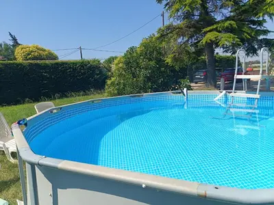 a swimming pool in a yard with two chairs at L'Escale Pernoise, 2-6 personnes in Pernes-les-Fontaines