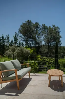 a green couch and a coffee table on a patio at Magnifique Villa à 5 minutes d'Aix in Aix-en-Provence