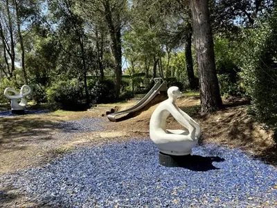 a sculpture of a woman sitting on a rock with a slide at Maison en Provence avec Piscine et Climatisation - FR-1-658-36 in Mallemort