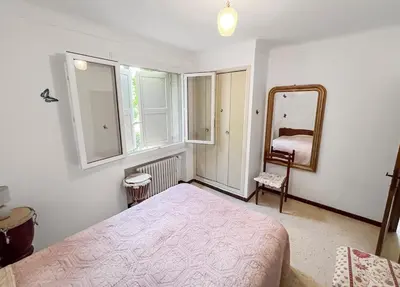 a bedroom with a bed and a mirror and a chair at Les Terrasses de l'Adrech in Banon