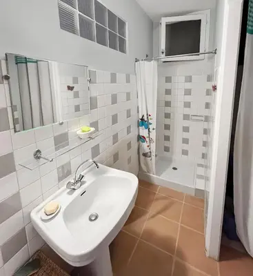 a white bathroom with a sink and a shower at Les Terrasses de l'Adrech in Banon