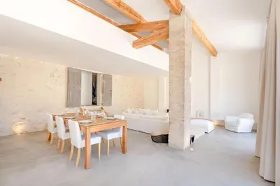 a dining room with a table and white furniture at La Bergerie Ferme du Montaiguet in Aix-en-Provence