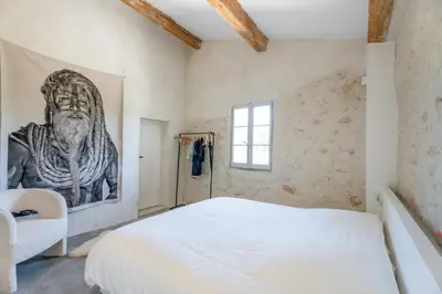 a bedroom with a white bed and a painting on the wall at La Bergerie Ferme du Montaiguet in Aix-en-Provence