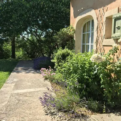 a walkway in front of a house with flowers at Provençal Villa With Luberon Views in Céreste