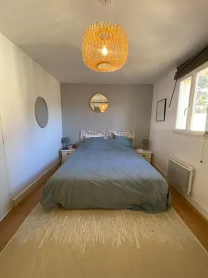 a bedroom with a bed and a chandelier at Maison village provençal in Éguilles