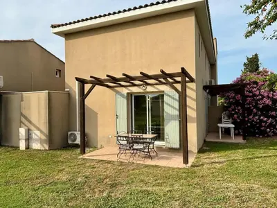 a patio with a table and chairs in front of a house at Douceur de vivre en Provence in Saint-Saturnin-lès-Avignon
