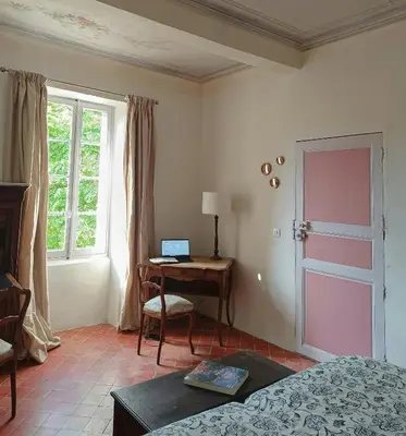 a bedroom with a bed and a desk with a laptop at Artist's Villa With Pool Near Aix-En-Provence in Alleins