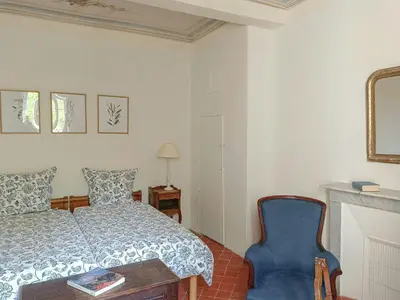 a bedroom with a bed and a blue chair at Artist's Villa With Pool Near Aix-En-Provence in Alleins