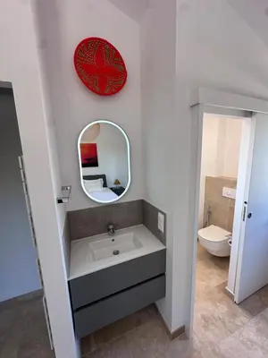 a bathroom with a sink and a mirror and a toilet at Keur Bouyo - Provençal Luxury Retreat in Saint-Saturnin-les-Apt