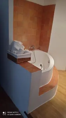 a bathroom with a bath tub with a wooden floor at Chez Rachel in La Bastide-des-Jourdans