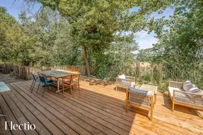 a wooden deck with a table and chairs on it at Cabane dIsmou Pool & Wood Design in La Roque-dʼAnthéron