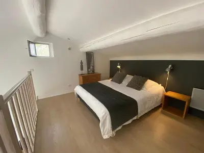a bedroom with a large bed and a staircase at Le clos de la Touloubre in Aix-en-Provence