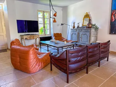a living room with leather chairs and a table at Villa de vacances à Gordes avec piscine partagée, La Bastide de Léa in Gordes