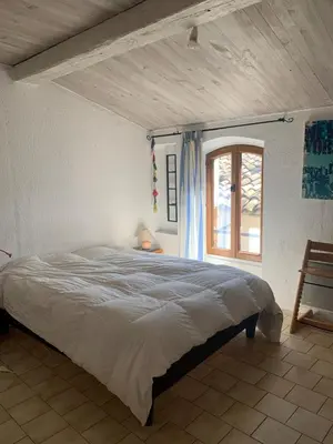 a bedroom with a large bed and a window at Charming village house in Alleins