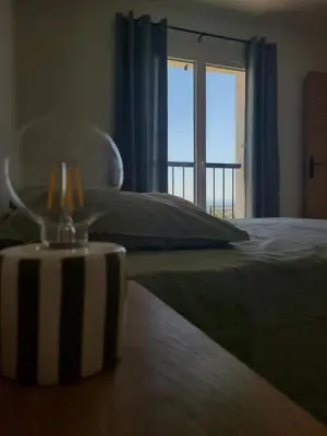 a bedroom with a bed with a glass item on a table at le petit 105 villa neuve avec piscine in La Fare-les-Oliviers
