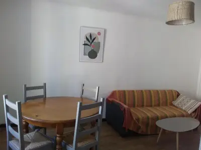 a living room with a table and a couch at Tranquility of Lub in this duplex in La Bastide-des-Jourdans