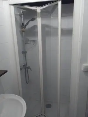 a shower with a glass door next to a toilet at Tranquility of Lub in this duplex in La Bastide-des-Jourdans