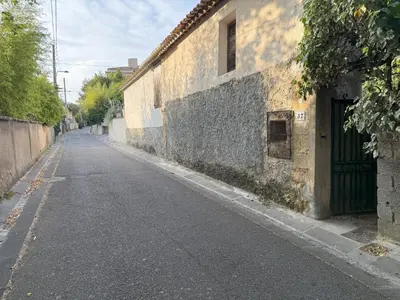 an empty street next to a building with a green door at Studio terrasse in Aix-en-Provence