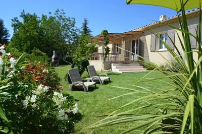 a yard with two chairs and some flowers at les lauriers in Caromb