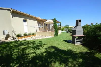 a yard with a house and a grassy yard with a fireplace at les lauriers in Caromb