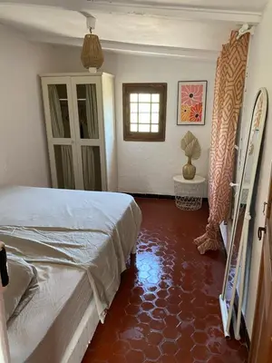 a bedroom with a bed and a red floor at Maison typique provençale au calme absolu dans le triangle d or a Bonnieux in Bonnieux