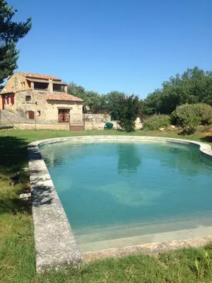 a large pool of water in front of a house at Maison typique provençale au calme absolu dans le triangle d or a Bonnieux in Bonnieux