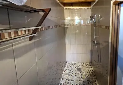 a bathroom with a shower and a tiled floor at La maison de l'olivier in Saint-Saturnin-les-Apt
