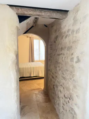 a hallway with a room with a bed and a window at Place ô sorgue ! in LʼIsle-sur-la-Sorgue