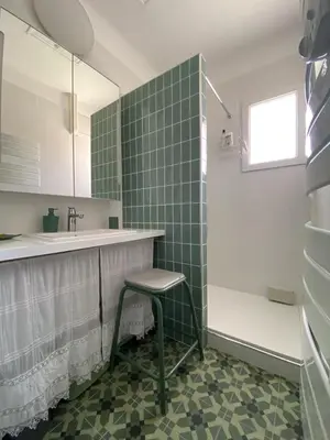 a bathroom with a stool next to a sink at Chez Simone, maison calme et indépendante, piscine in Cavaillon