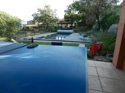 a swimming pool with a blue table in a yard at Vues imprenables, calme, nature, confort in Bonnieux
