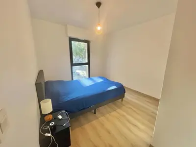 a bedroom with a blue bed and a window at Salon de Provence in Salon-de-Provence