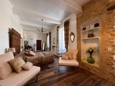 a bedroom with a bed and a couch in a room at Domaine Régine in Le Puy-Sainte-Réparade
