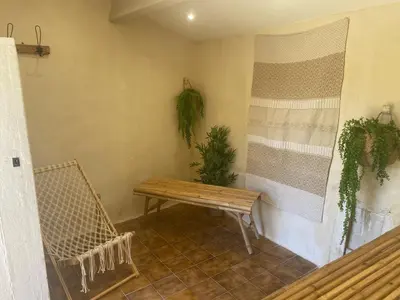 a porch with a bench and plants on the wall at Domaine Régine in Le Puy-Sainte-Réparade