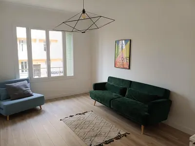 a living room with a green couch and a chair at 2 bedroom apartment in the city center in Aix-en-Provence