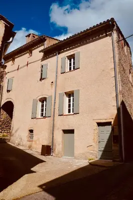 a large brick building with white windows and doors at La Serre in Viens